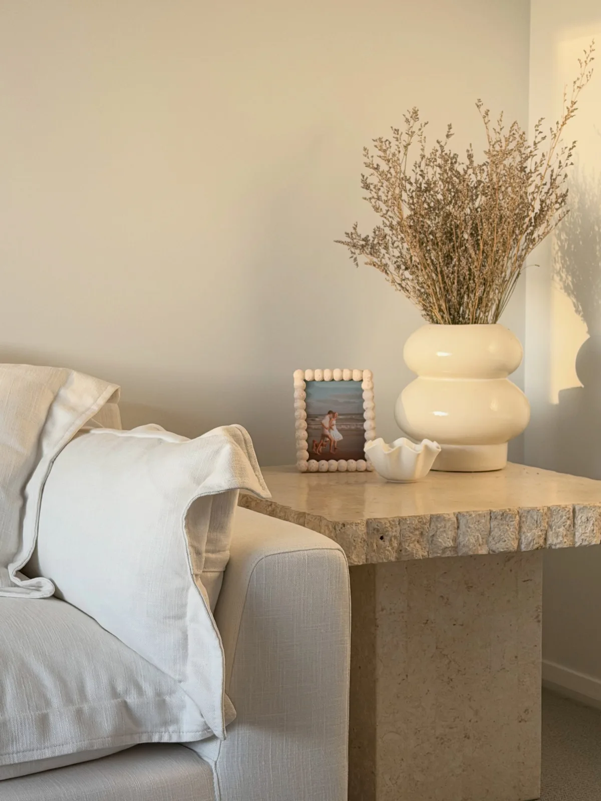 Square cream stone side table with a textured edge beside our lounge