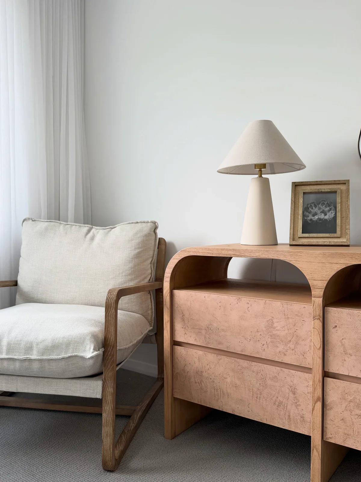 Cream table lamp with a tapered base and shade on our bedroom drawers