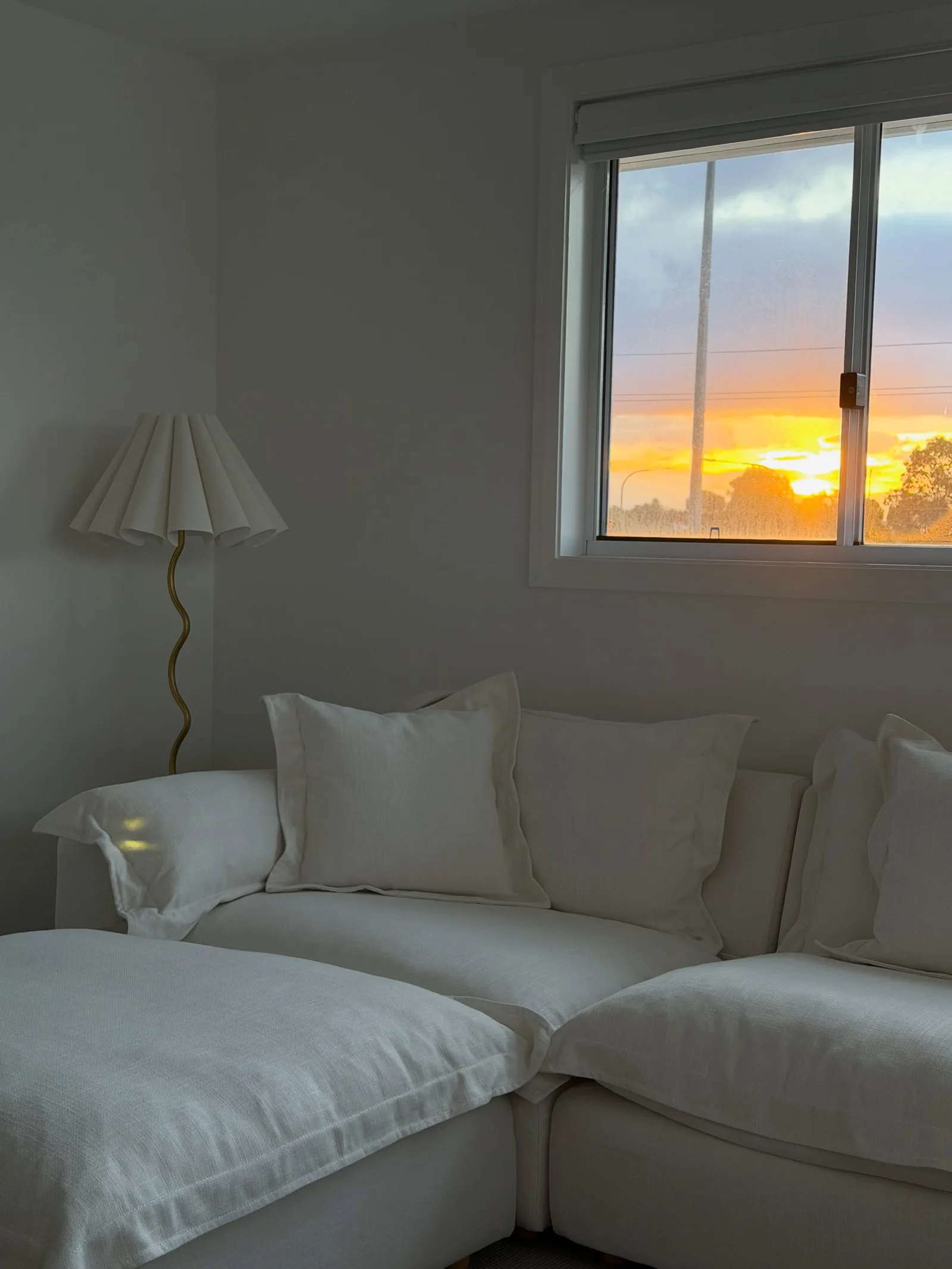Cream family-room sofa with layered cushions in the afternoon light